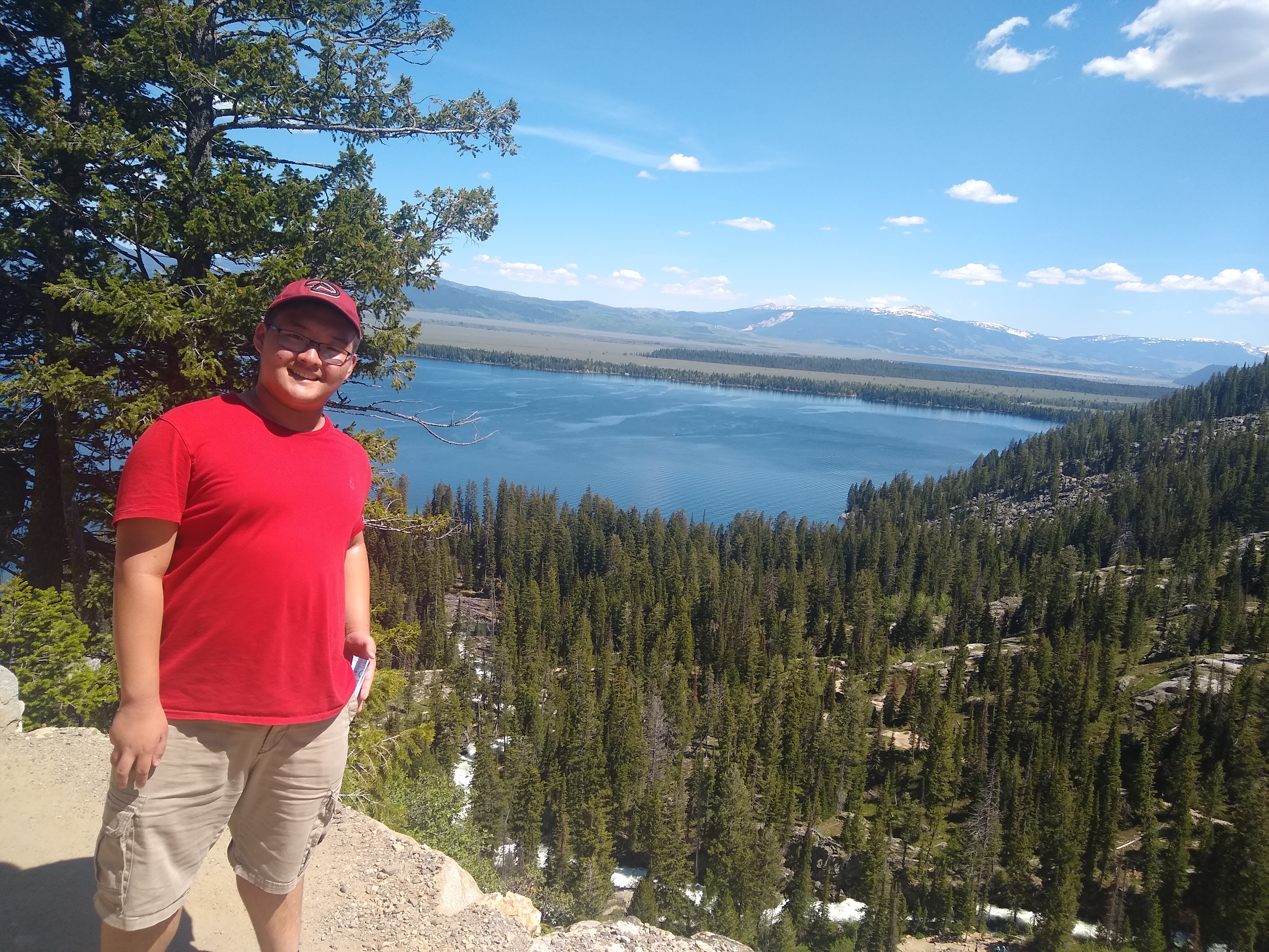 A picture of William Ko looking out into a blue lake
